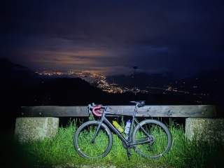 Rennrad im Dunklen, Lichtermeer im Hintergrund