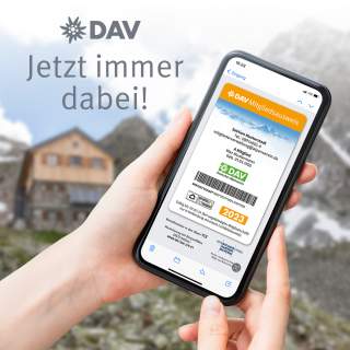 Hand hält Smartphone mit digitalem DAV-Mitgliedsausweis vor verschwommenem Bergpanorama und Hütte, daneben Text „Jetzt immer dabei!“ und DAV-Logo.