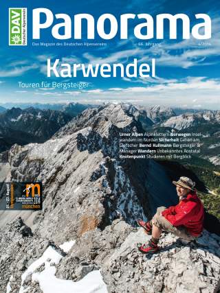 Titelblatt des Magazins „Panorama“ mit Bergpanorama der Karwendelberge, eine Person in roter Jacke sitzt auf felsigem Gipfel unter blauem Himmel.